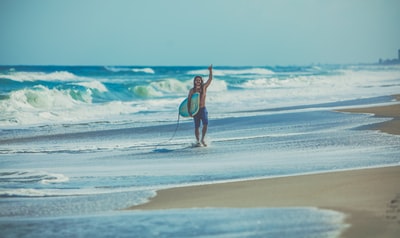 男人拿着冲浪板在海滩
